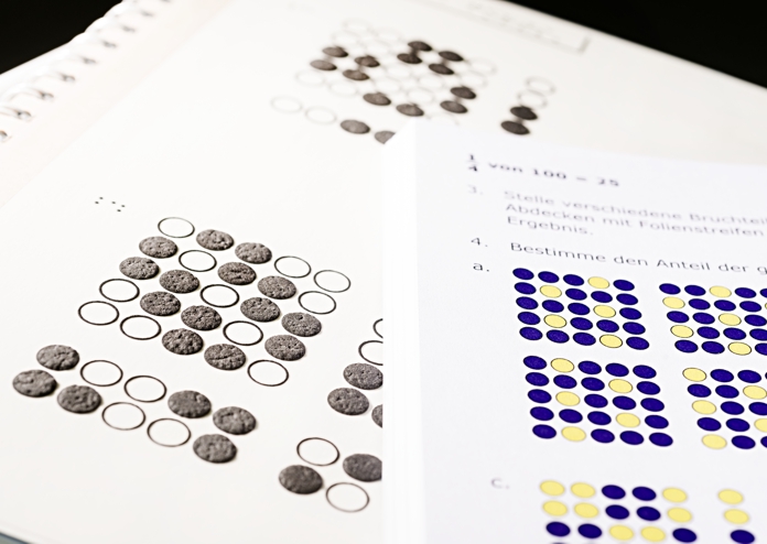 Lehrbuch in Braille Abbildung einer Seite aus einem Mathematik-Lehrbuch in Braille mit Relief.