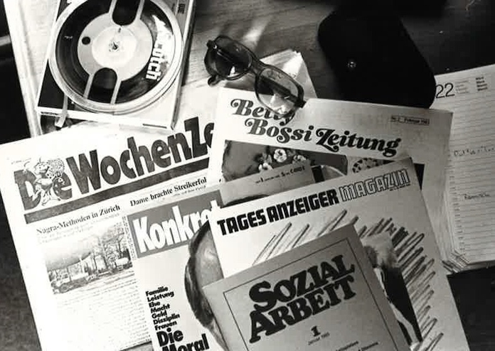 Tonband-Zeitschriften Abbildung eines Tonband-Abspielgeräts sowie einigen Zeitschriften wie zum Beispiel «Die Wochenzeitung», «Betti Bossi Zeitung» und «Sozialarbeit».